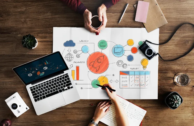 Strategi kampanye menggunakan tools influencer marketing dengan ilustrasi diagram, laptop, kamera, dan catatan rencana kampanye.